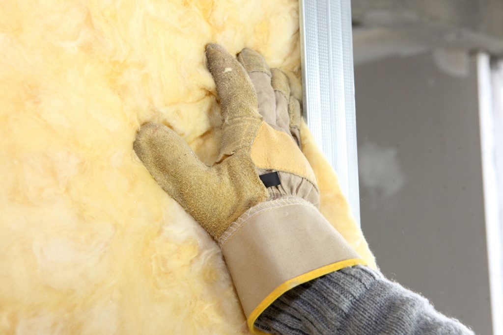 Gloved hand touching insulation