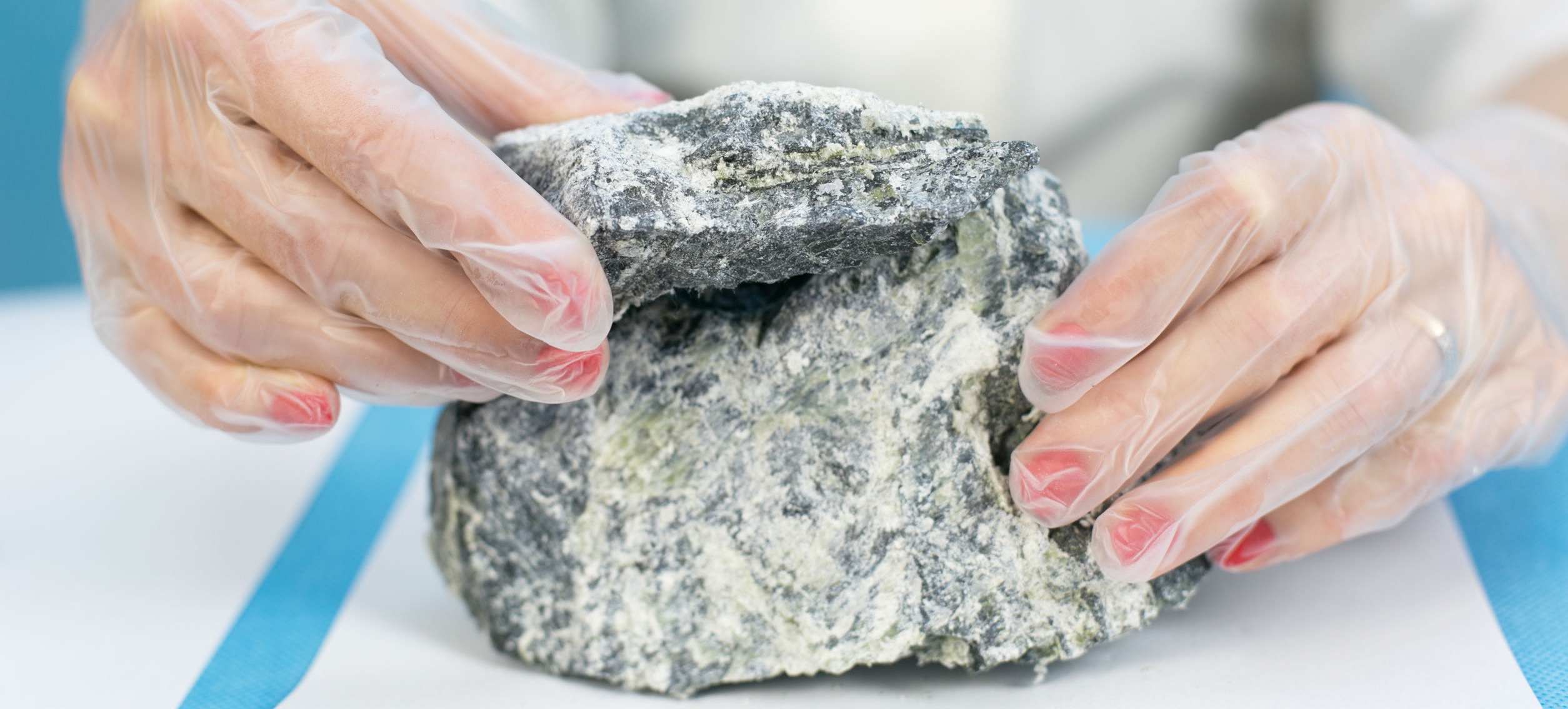 Female hands hold asbestos mineral sample