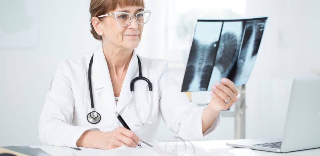 Pulmonologist with stethoscope looking at an X-ray picture of lungs