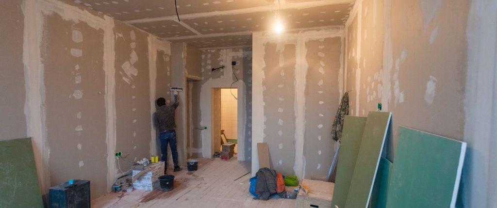 Person installing sheetrock for remodeling project