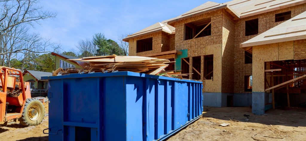 Dumpster and construction materials at building site