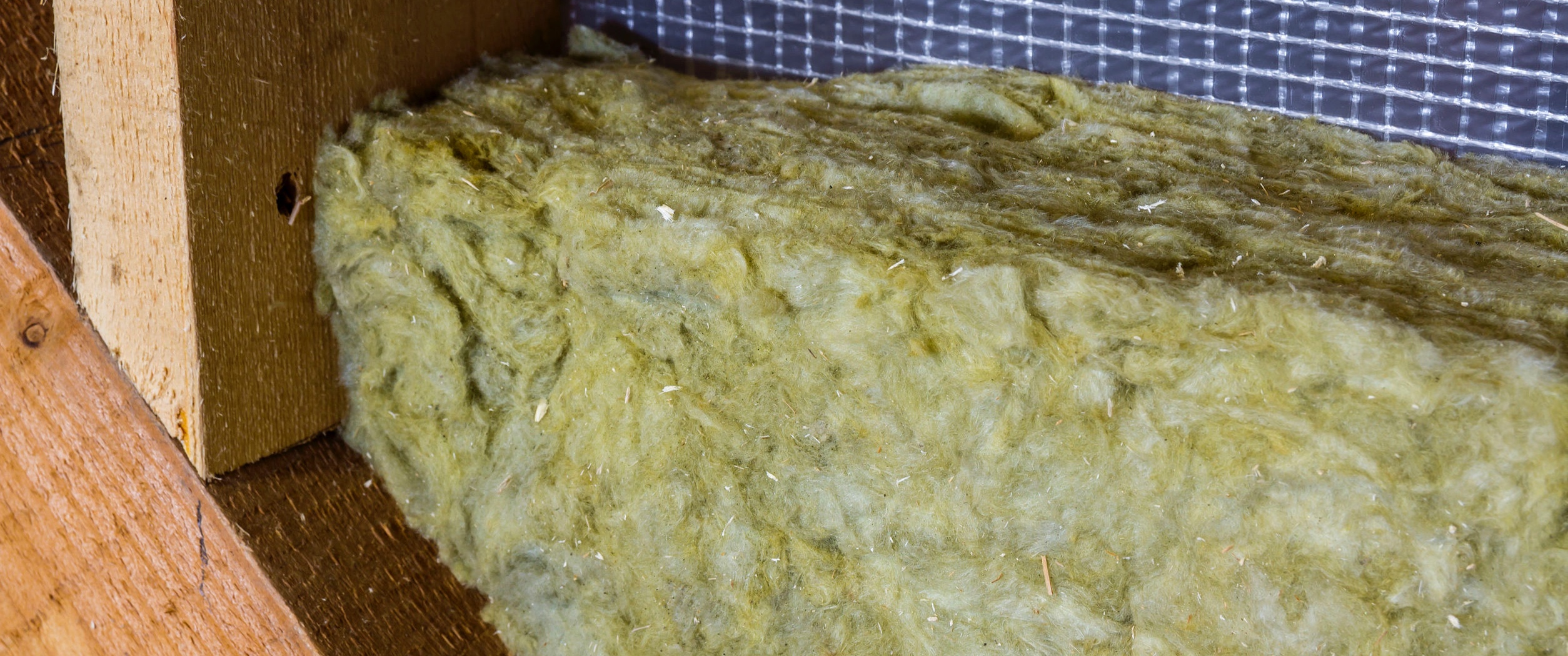 Thermal insulation mineral rock wool installation at the new building attic wall