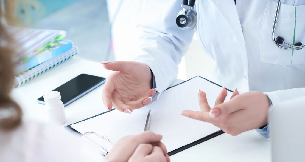 Patient listening intently to a female doctor explaining patient symptoms