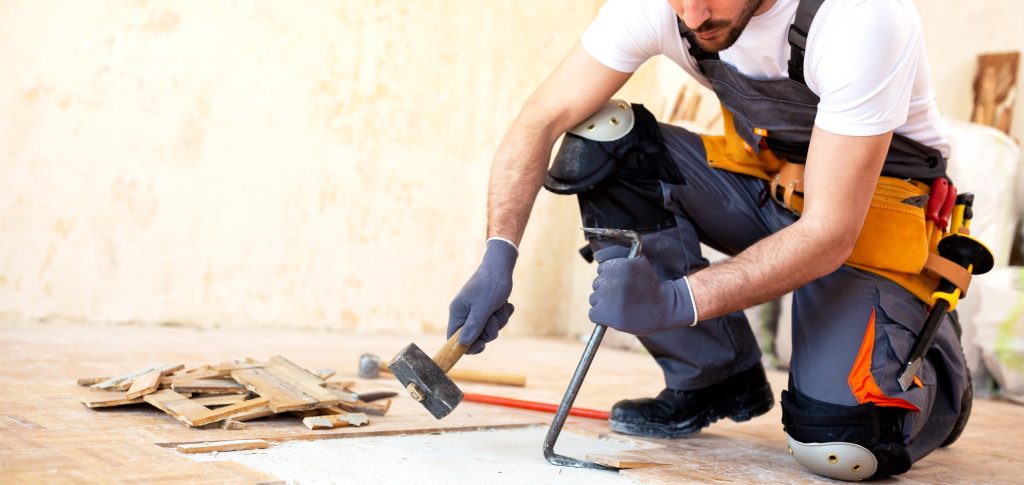 Worker removing old flooring with adequate removal tolls