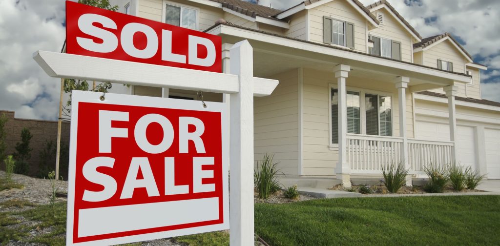 House with for sale and sold signs in front yard