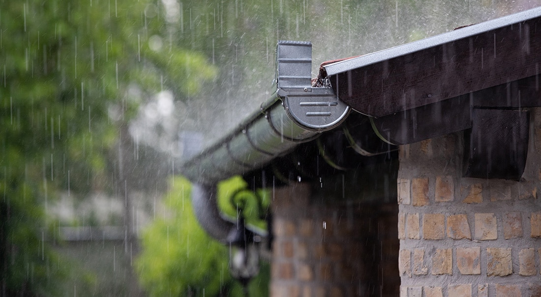 Heavy rain falling on a roof and gutter