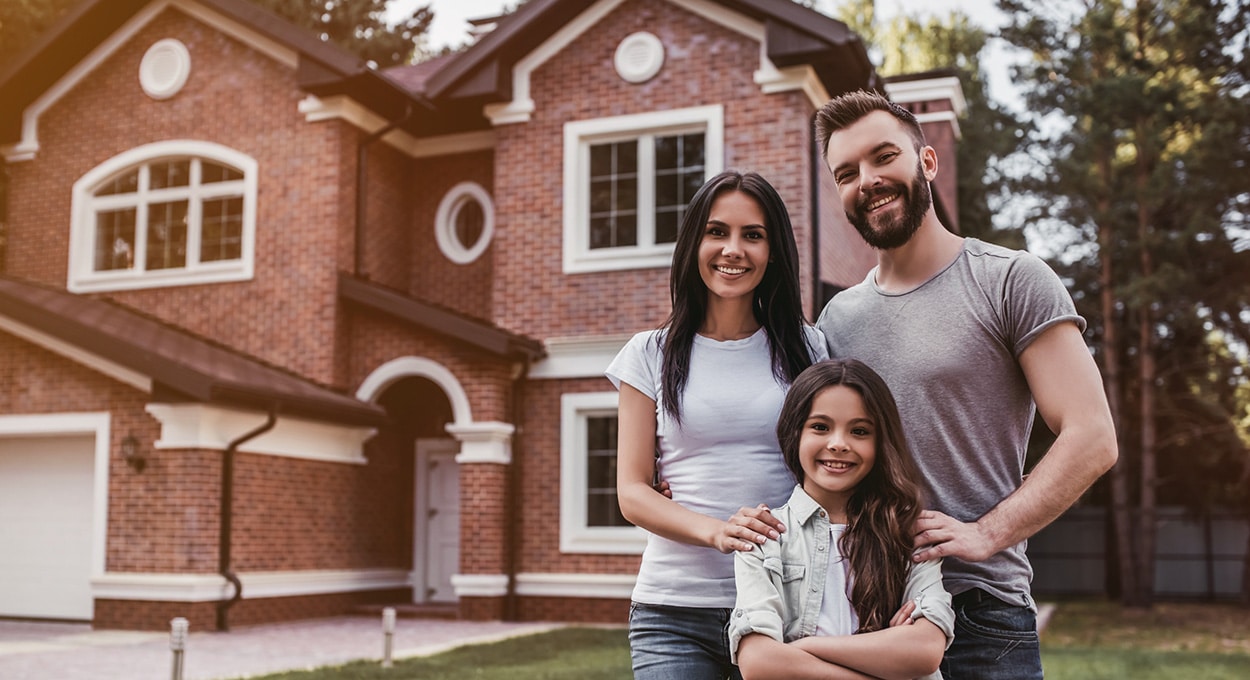 Family standing in the front yard of their home