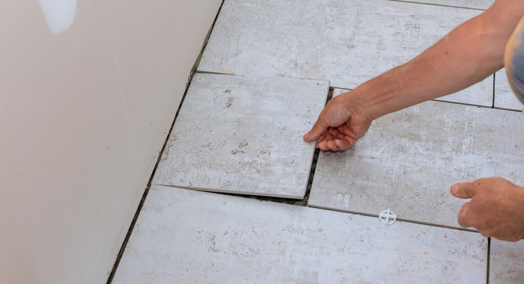 Worker installing a floor tile