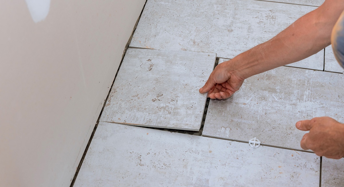 Worker installing a floor tile